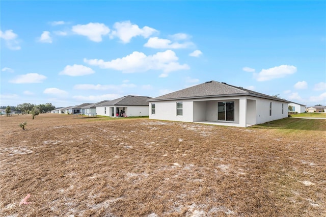 back of property featuring a lawn and a patio