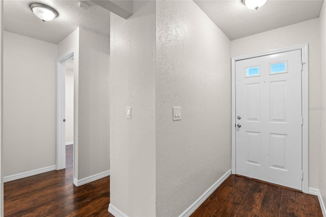 entrance foyer featuring a textured ceiling and dark hardwood / wood-style floors