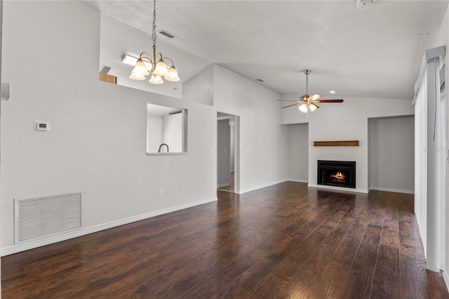 unfurnished living room with vaulted ceiling, ceiling fan with notable chandelier, and dark hardwood / wood-style floors