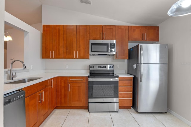 kitchen featuring stainless steel appliances, light tile patterned flooring, lofted ceiling, hanging light fixtures, and sink