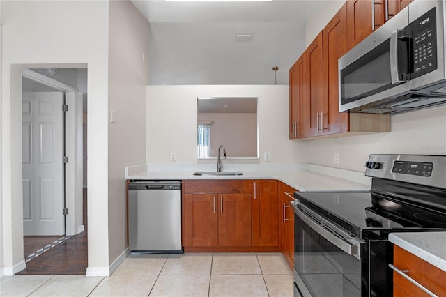 kitchen with light tile patterned floors, sink, and stainless steel appliances