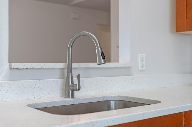 interior details featuring light stone counters and sink