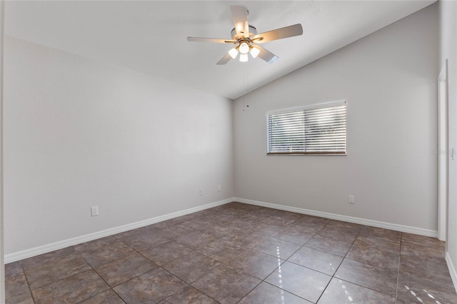 empty room with ceiling fan, dark tile patterned floors, and lofted ceiling