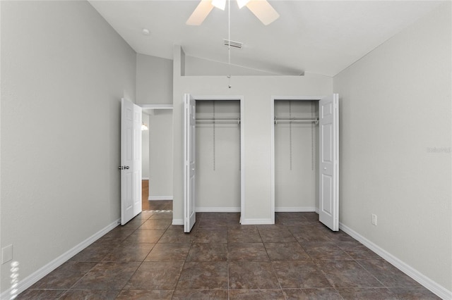 unfurnished bedroom featuring ceiling fan, lofted ceiling, and two closets