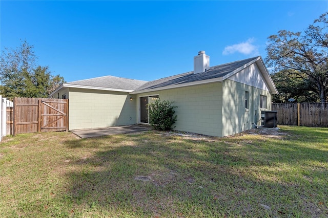 back of house with a yard and central AC