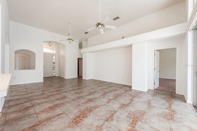 empty room with a towering ceiling and ceiling fan