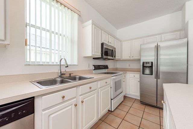 kitchen with white cabinets, appliances with stainless steel finishes, light tile patterned floors, and sink