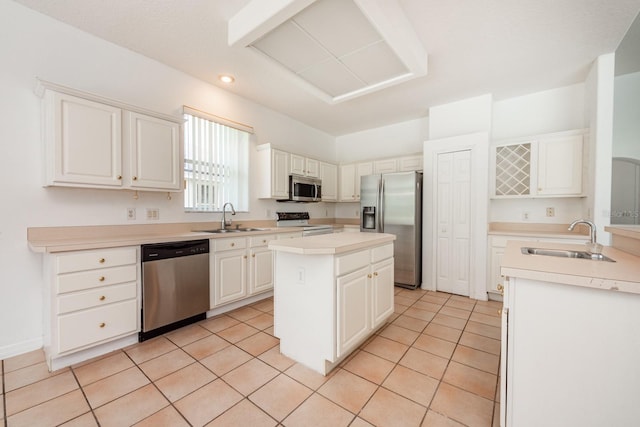 kitchen featuring appliances with stainless steel finishes, white cabinetry, a kitchen island, and sink