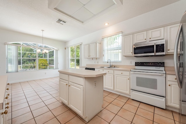 kitchen featuring a center island, sink, hanging light fixtures, white cabinets, and appliances with stainless steel finishes