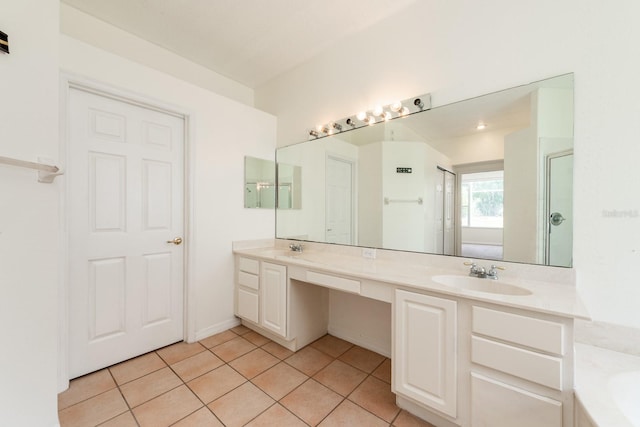 bathroom with tile patterned flooring, vanity, and walk in shower