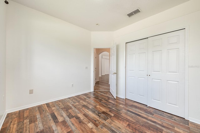 unfurnished bedroom featuring dark hardwood / wood-style floors and a closet