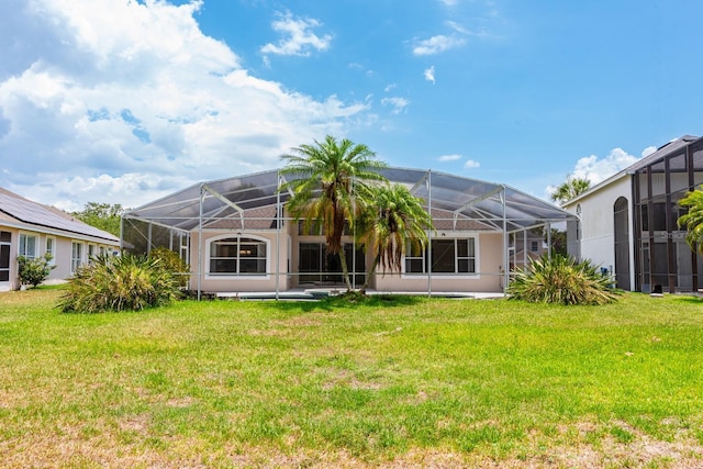 back of house with a lawn and a lanai