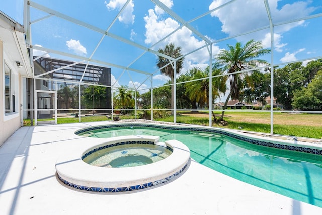 view of pool featuring glass enclosure and an in ground hot tub