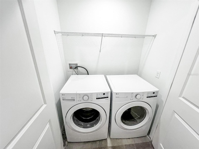 laundry room with hardwood / wood-style flooring and independent washer and dryer