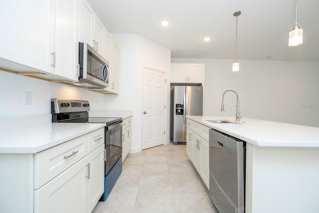 kitchen featuring white cabinetry, sink, stainless steel appliances, decorative light fixtures, and a kitchen island with sink