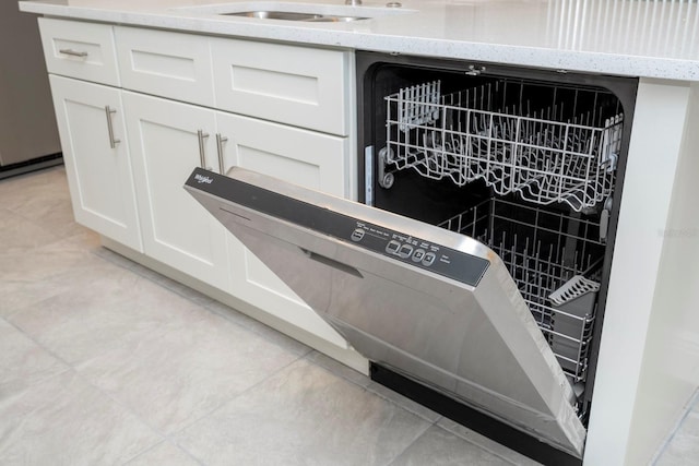 details featuring dishwasher, white cabinetry, and light stone counters