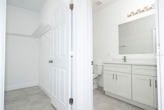 bathroom with tile patterned flooring, vanity, and toilet