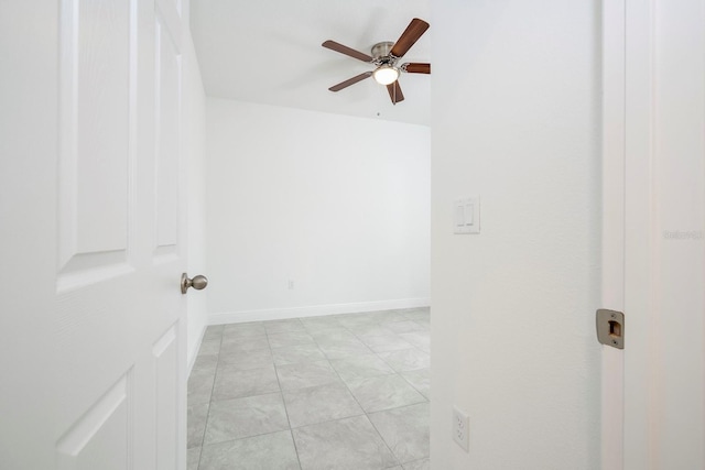 spare room with ceiling fan and light tile patterned floors