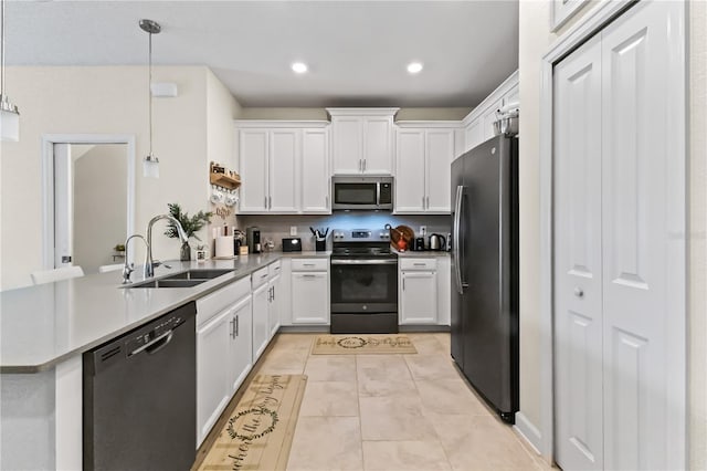 kitchen with kitchen peninsula, stainless steel appliances, sink, white cabinetry, and hanging light fixtures