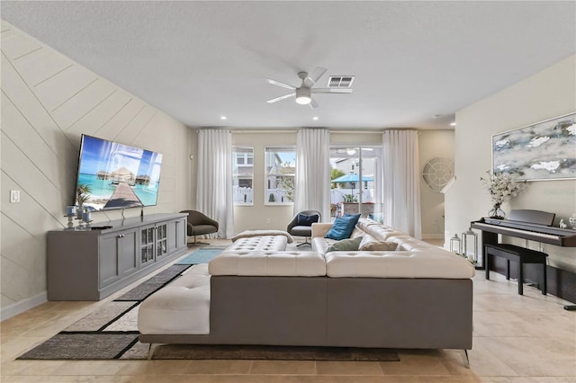 tiled living room with ceiling fan and wood walls