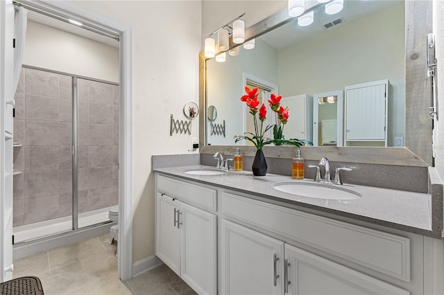 bathroom with walk in shower, tile patterned floors, vanity, and toilet