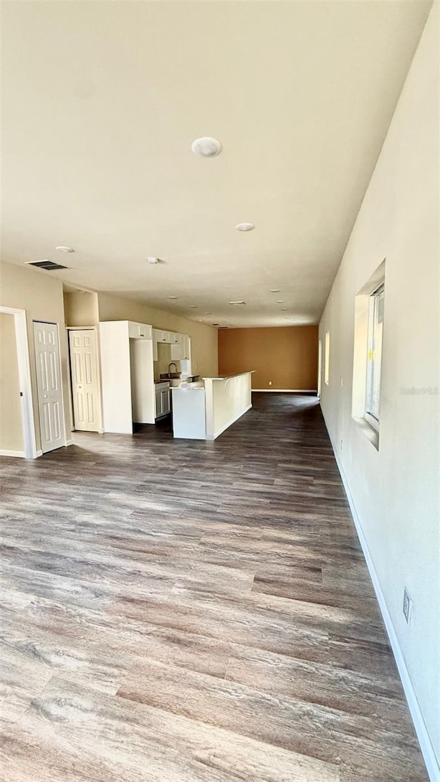 322 N 6th St, Haines City, FL 33844 - unfurnished living room with baseboards and dark wood finished floors