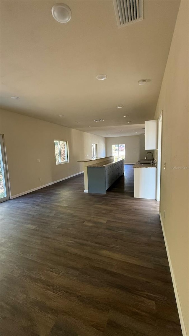 322 N 6th St, Haines City, FL 33844 - unfurnished living room featuring healthy amount of natural light, dark wood-type flooring, and recessed lighting