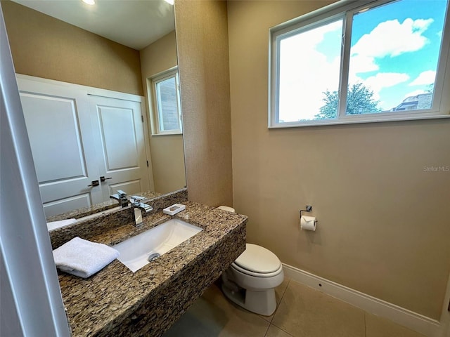 bathroom with toilet, tile patterned flooring, and sink