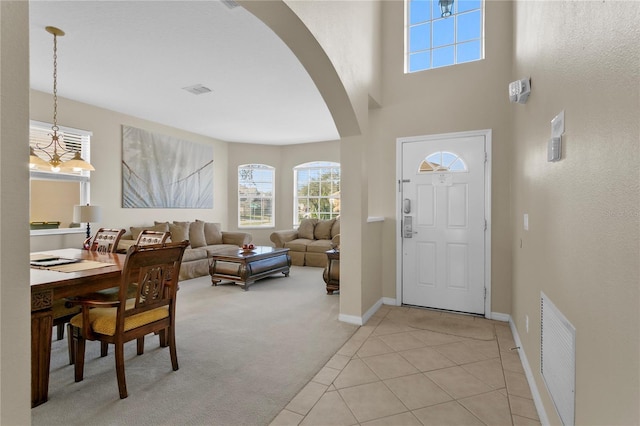 entrance foyer featuring light carpet, a high ceiling, and a chandelier