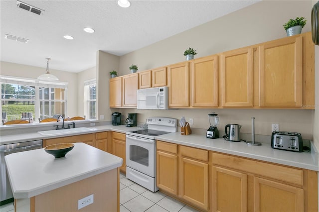 kitchen with light brown cabinets, white appliances, a textured ceiling, and sink