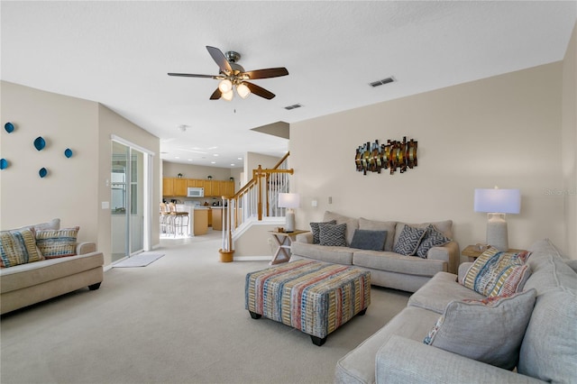 128 Higher Combe Dr, Davenport, FL 33897 - living area featuring stairway, light colored carpet, and ceiling fan