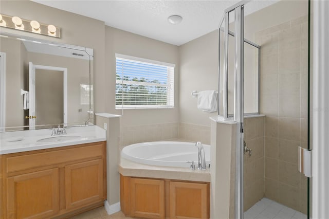 128 Higher Combe Dr, Davenport, FL 33897 - bathroom featuring vanity, a stall shower, a bath, a textured ceiling, and tile patterned flooring