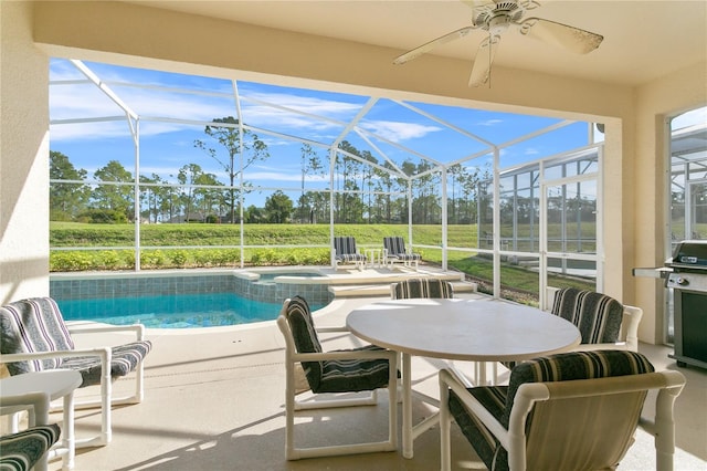 view of swimming pool featuring ceiling fan, glass enclosure, an in ground hot tub, and a patio