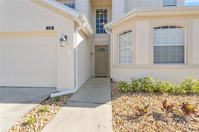 128 Higher Combe Dr, Davenport, FL 33897 - doorway to property with stucco siding and an attached garage