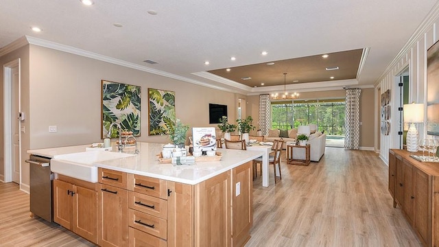 kitchen featuring dishwasher, a center island with sink, sink, light hardwood / wood-style flooring, and a notable chandelier