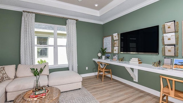 living room featuring hardwood / wood-style flooring, ornamental molding, and a tray ceiling