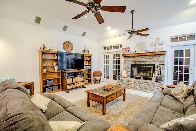 living room featuring light tile patterned floors, ceiling fan, lofted ceiling, a fireplace, and french doors