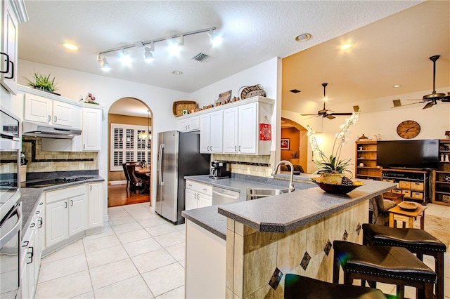 kitchen with a kitchen bar, white cabinetry, stainless steel appliances, sink, and kitchen peninsula