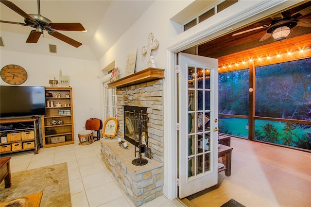 living room featuring a fireplace, tile patterned floors, ceiling fan, and vaulted ceiling