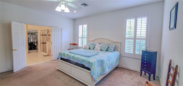carpeted bedroom featuring baseboards, recessed lighting, a walk in closet, and a ceiling fan