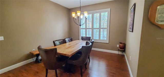 dining area with a chandelier, dark wood-type flooring, and baseboards
