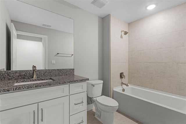 full bathroom featuring vanity, tiled shower / bath combo, and toilet