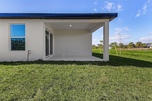 back of property with a yard and a patio