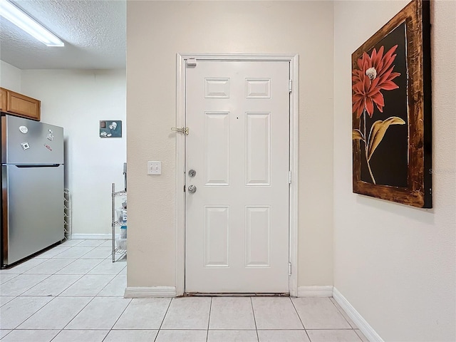 tiled entryway featuring a textured ceiling