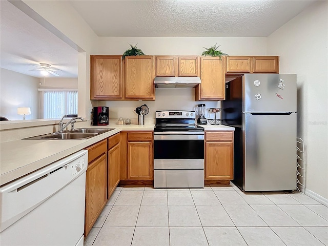 kitchen with ceiling fan, sink, stainless steel appliances, and a textured ceiling