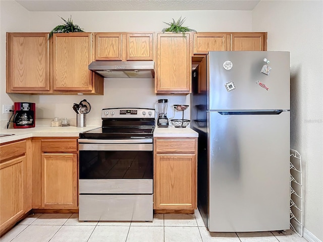 kitchen with light tile patterned floors, light brown cabinetry, and appliances with stainless steel finishes