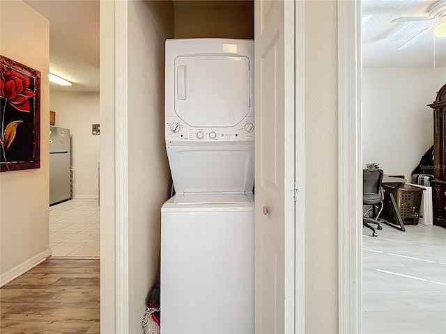 washroom with ceiling fan, light tile patterned floors, and stacked washer and dryer