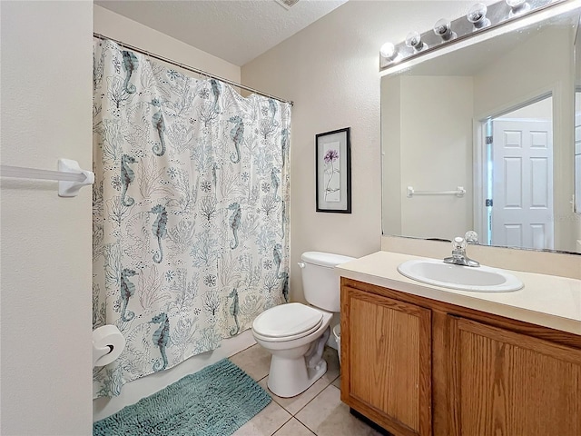 bathroom with tile patterned flooring, vanity, toilet, and a textured ceiling