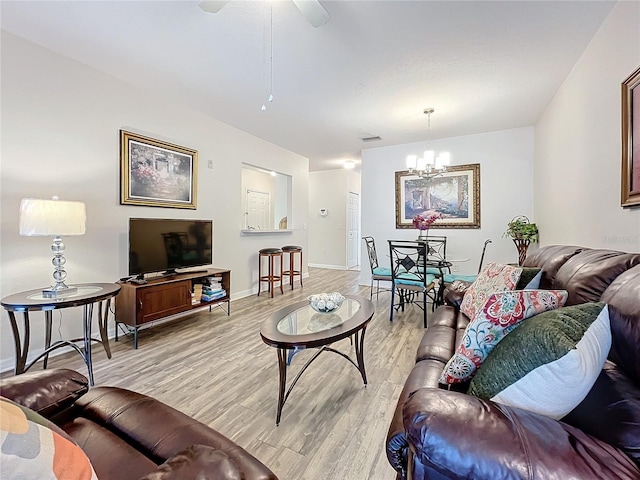 living room featuring light hardwood / wood-style flooring and ceiling fan with notable chandelier