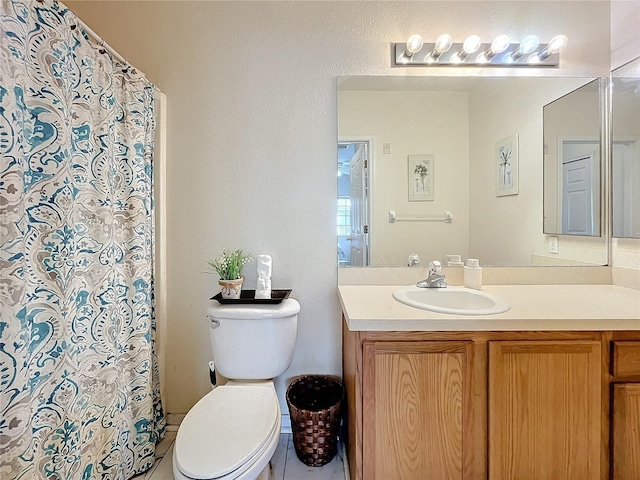 bathroom with tile patterned floors, curtained shower, vanity, and toilet